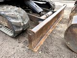 a bulldozer sitting on the ground next to a pile of rocks
