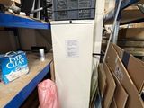 un réfrigérateur blanc au milieu d'une pièce remplie de cartons