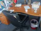 a desk with a chair and a book shelf in the corner