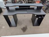 a black computer desk with a keyboard on top of it