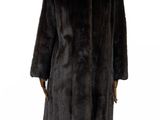 un manteau de fourrure noir posé sur un support de mannequin