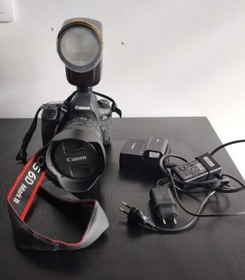 un appareil photo Canon posé sur une table à côté d'un chargeur