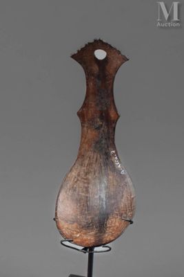 sculpture représentant un vase en bois posé sur un socle métallique, sur fond gris