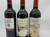 trois bouteilles de vin sont alignées sur une surface blanche