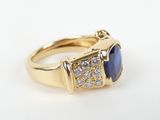 a close up of a gold ring with a blue stone and diamonds