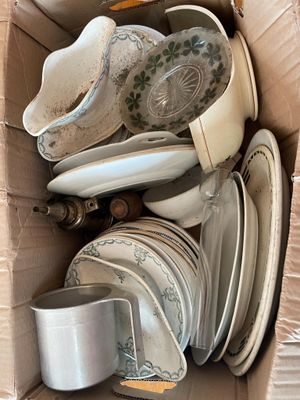 a cardboard box full of plates and bowls in it