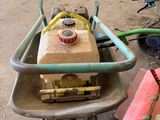 a wheelbarrow with a pump attached to it next to a wheelbarrow with a hose attached to it