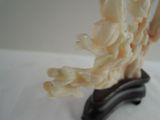 a sculpture of flowers on a black stand on a white surface
