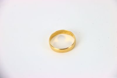 gros plan d'une bague en or sur une surface blanche
