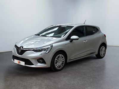 une voiture argentée garée dans une pièce blanche au sol noir
