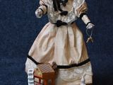 a figurine of a woman in a dress and hat