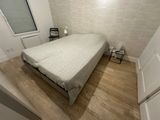 a bed that is in a small room with wood floors