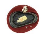a red hat with a gold broocher on it