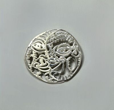 a close up of a silver coin on a white surface