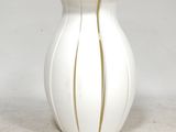 a white vase with a gold stripe on it