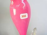 a pink balloon with a sticker on it sitting on a table