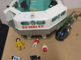 a small toy boat on a table with other toys around it