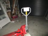a red hand truck with a sign on it in a garage