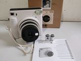a white camera sitting on top of a table next to a box