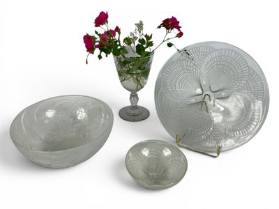 a glass bowl, plate, and vase with flowers in it