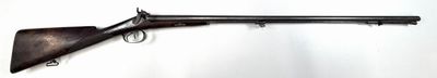 an old gun mounted on a wall in a white room