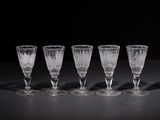 four empty wine glasses lined up on a table