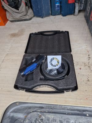 a tool in the case on the floor next to other tools