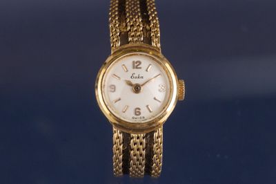 Gros plan sur une montre-bracelet en or entourée d'une chaîne