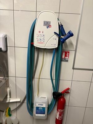 a toilet with a hose attached to it in a bathroom