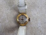 a close up of a wrist watch with a white strap