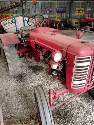 a red tractor that is parked in a garage