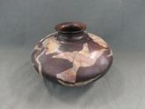un vase marron orné d'un motif, posé sur une table