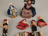 many dolls that are sitting on a table together