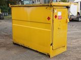 a yellow dumpster sitting in the middle of a dirt lot