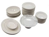 a lot of white plates and bowls on the table