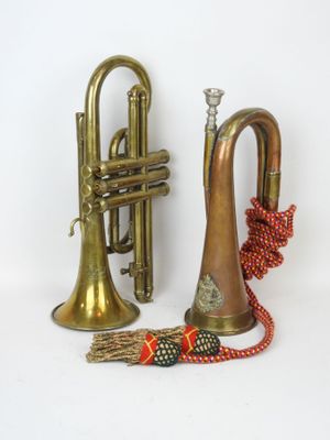 two brass trumpets and a red ribbon on a white background