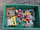 a green container filled with assorted items on the ground