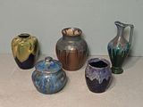 five different vases sitting on a table next to each other
