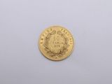 a close up of a gold coin on a white surface