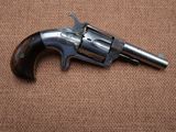 a gun that is sitting on a brown surface