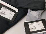 a label on the back of a jacket that is next to a pair of pants