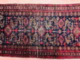 a close up of a blue and red rug on a pink background