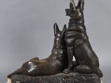 sculpture of two dogs sitting on a marble base with a gray background