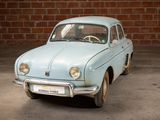 a small blue car parked in front of a brick wall