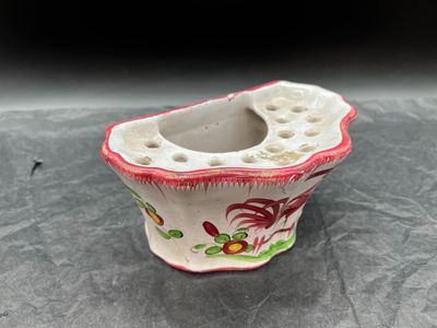 un petit vase orné d'un motif rouge et blanc