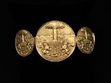 a close up of three gold coins on a black background