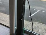une borne de recharge pour voitures électriques devant une grande baie vitrée