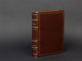 a brown book sitting on top of a gray surface