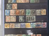 someone holding up a book with a lot of stamps on it