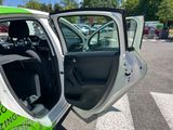 a green and white car parked in a parking lot